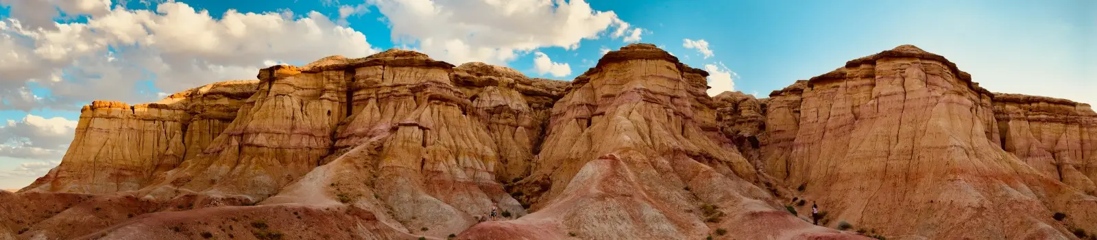 The layered red and gold cliffs of the Gobi under a bright sky