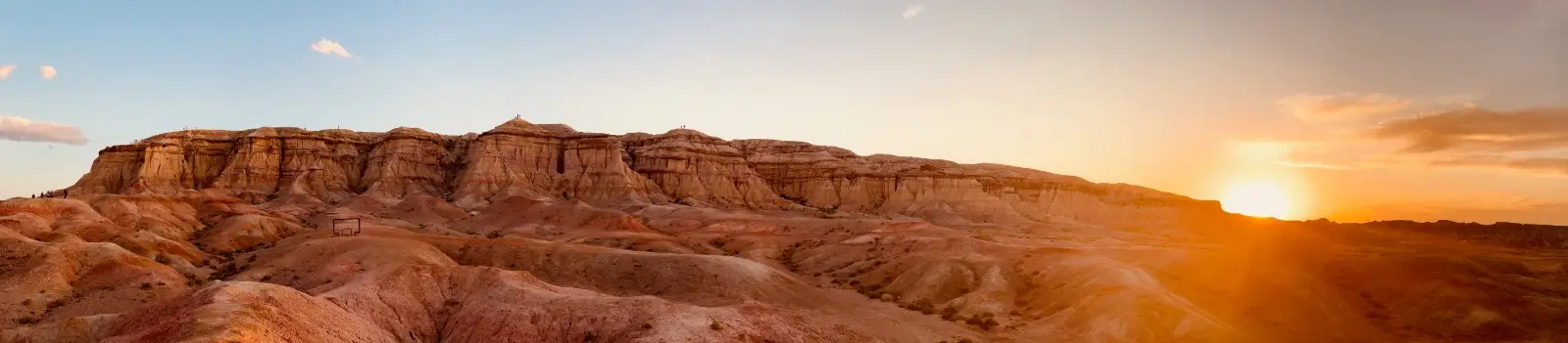 The Gobi cliffs at sunset, the sun dropping behind the escarpment